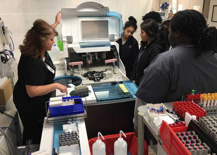 Graves Gilbert Clinic Lab Technician explaining GGC Lab Machine